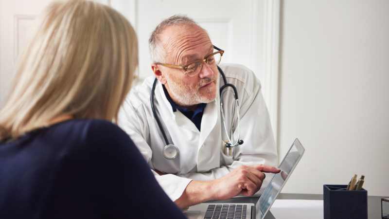 Doctor showing patient something on a laptop